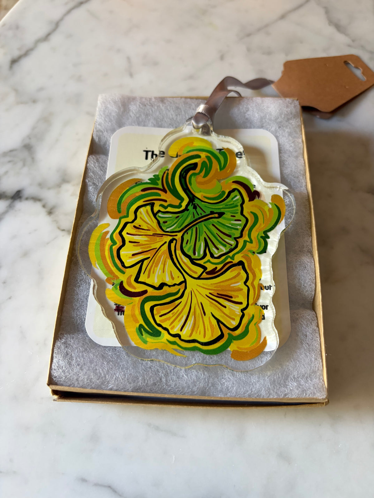 Ginkgo leaf acrylic ornament in gray box on cream backing, front view