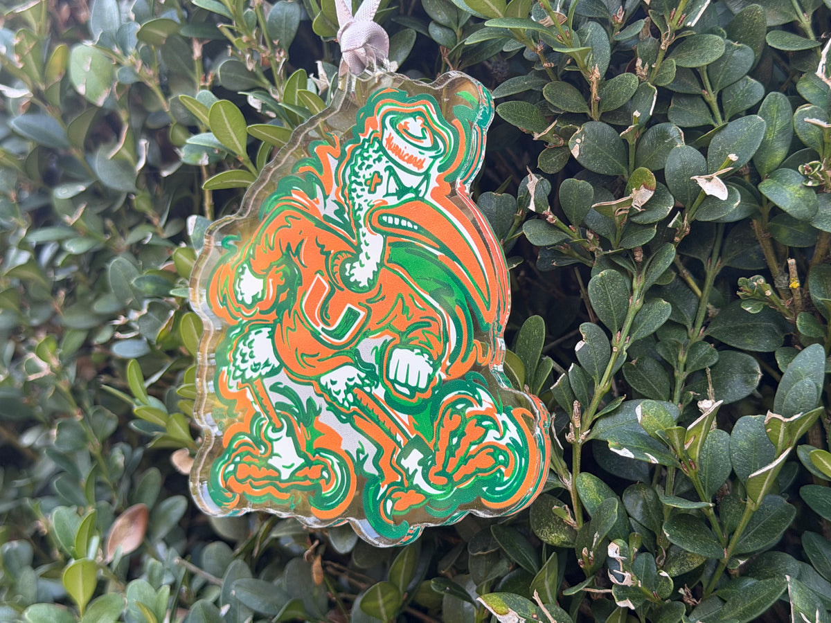 Hanging mascot ornament featuring orange-and-green figure with outlined details and top loop