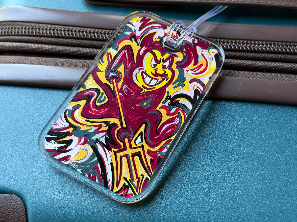 Mascot bag tag close-up with devil face illustration and blue lanyard