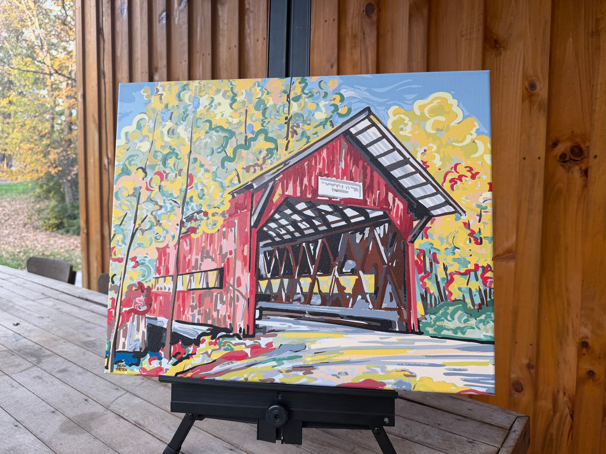 Wrapped canvas print of a red covered bridge amid colorful autumn foliage.