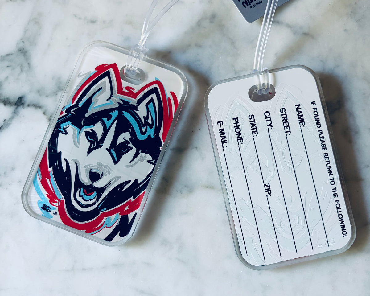 University of Connecticut mascot bag tag with husky graphic and white back, hanging