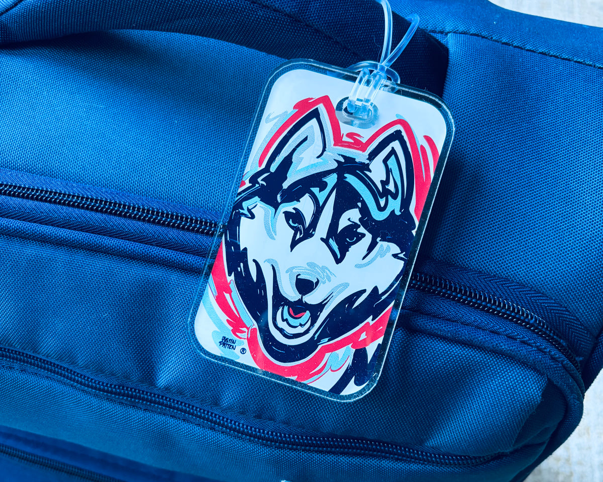 University of Connecticut mascot bag tag with husky face graphic on blue bag