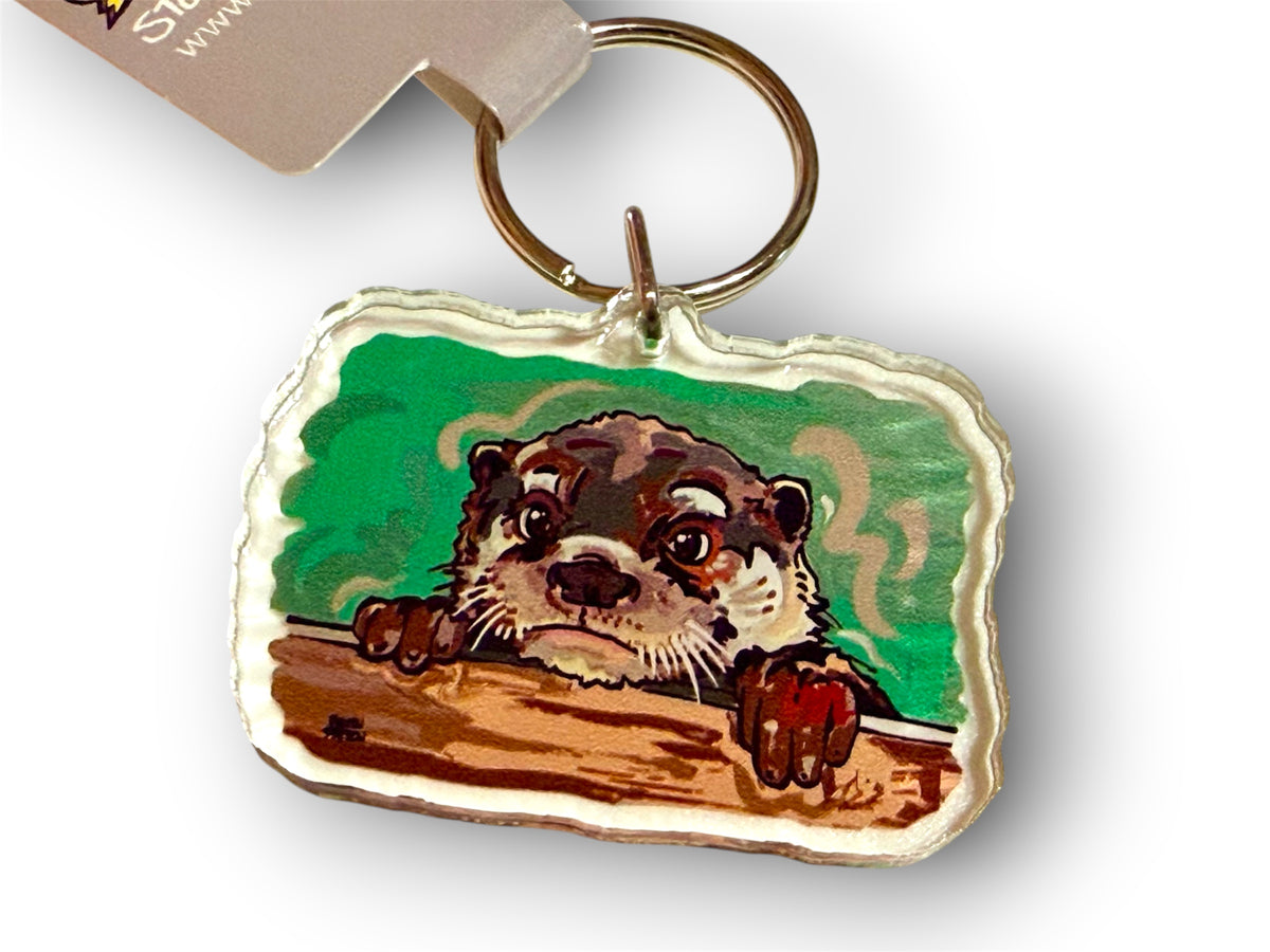 Otter keychain with stitched fabric tag and metal key ring, cartoon otter on green