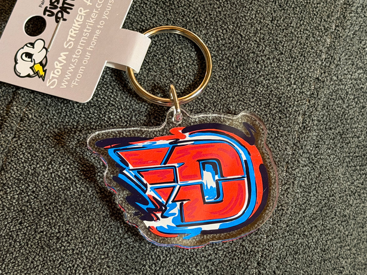 Key tag charm with colorful block 'D' logo and circular metal key ring