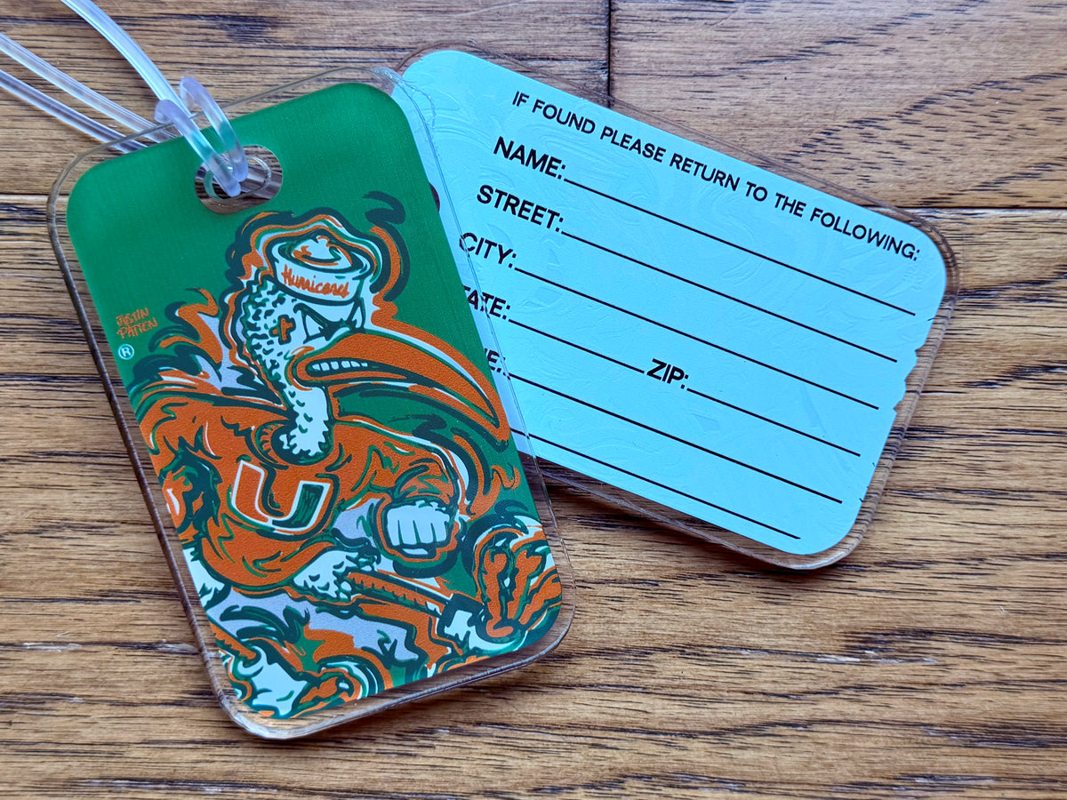 Green mascot bag tag with orange-and-teal graphic; blue return-address card backing.