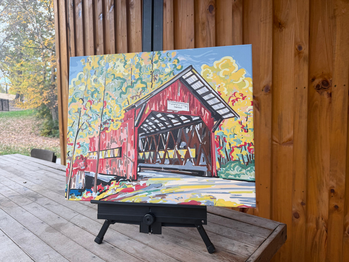 Wrapped canvas print showing a red covered bridge and colorful trees.