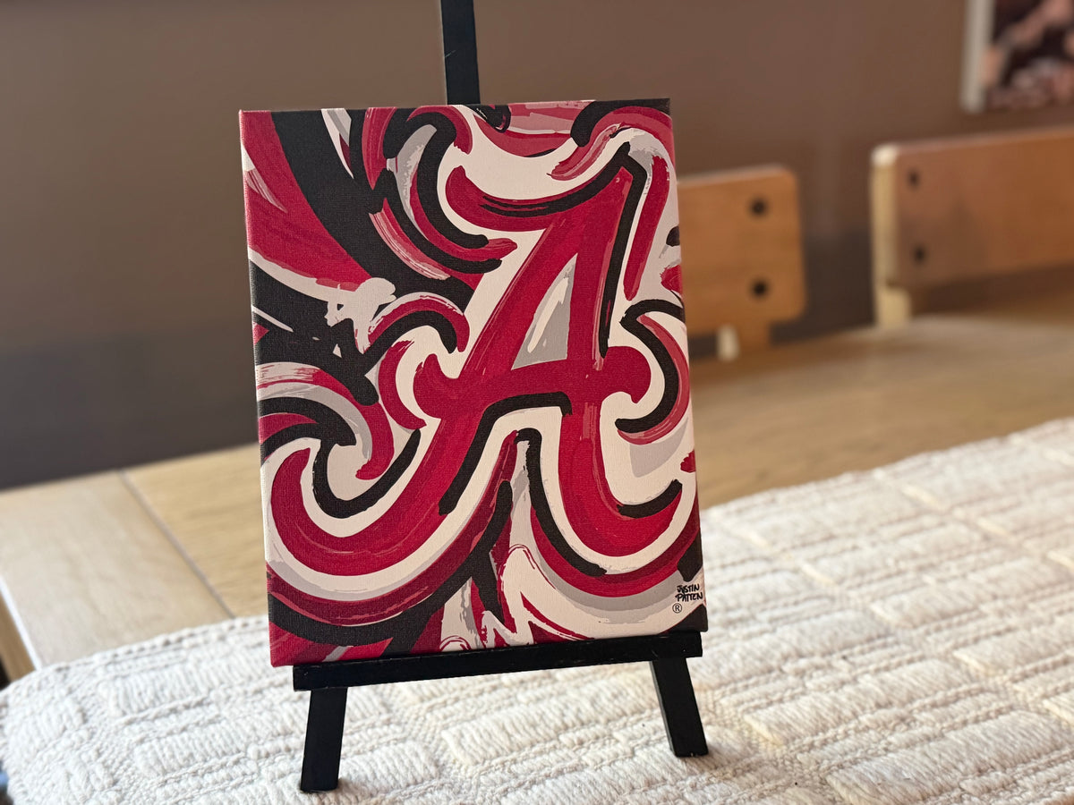 Wrapped canvas print on black easel, crimson, white and black abstract letter A design