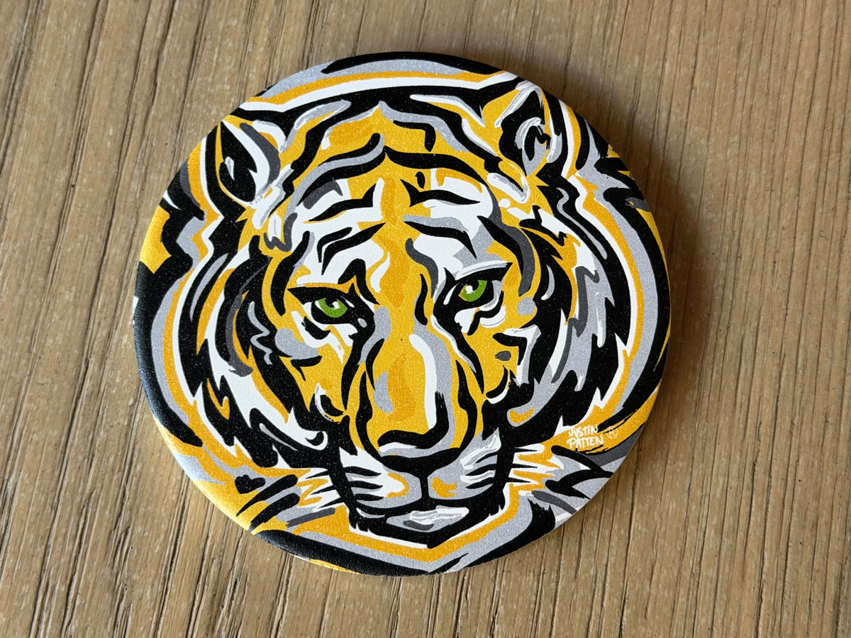 Round tiger face stone coaster with black, yellow, and white graphic design