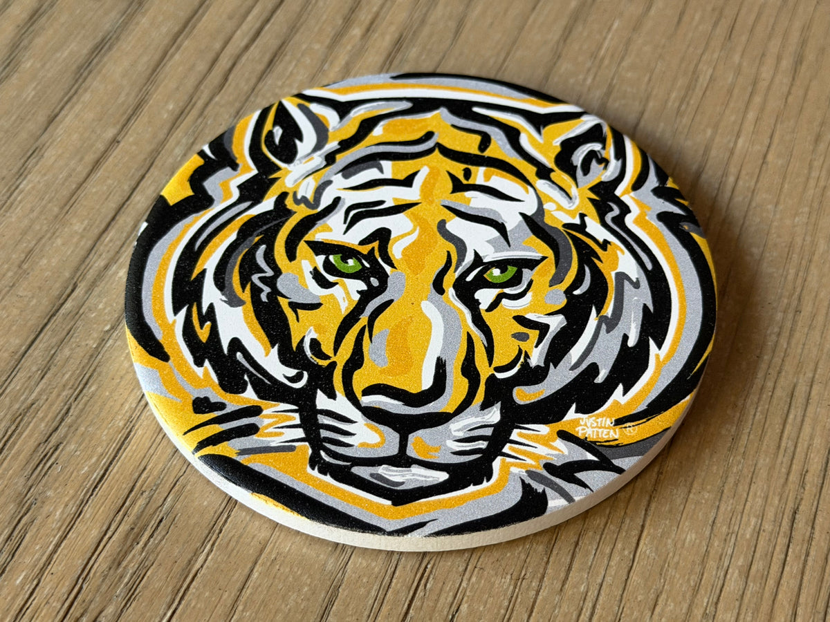 Round tiger face stone coaster, yellow and black with white accents, top view