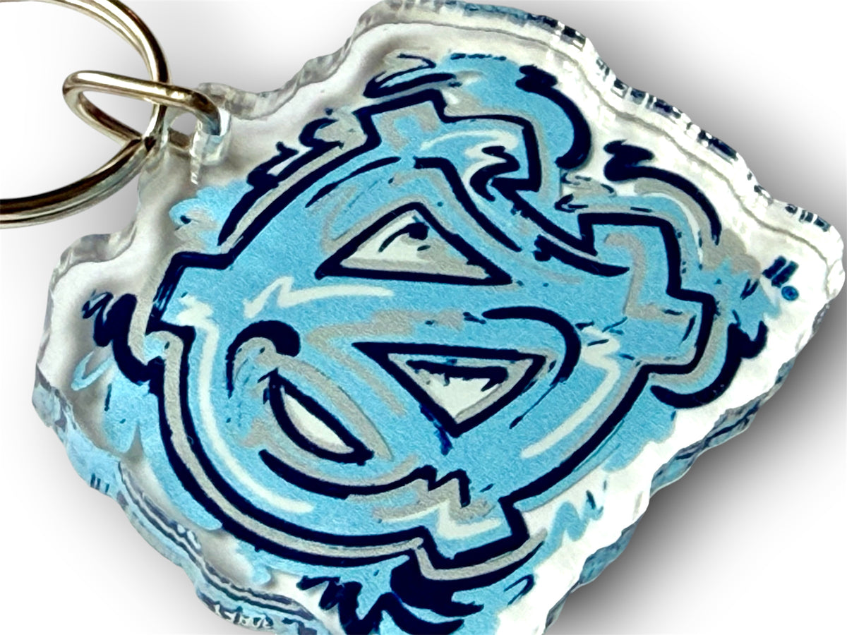 Close-up of the keychain's blue and white NC logo and attached metal ring